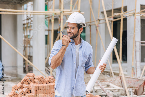 adult professional male builder work in construction site. Architect home project chief engineer with floor plan.