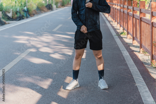 Asian young man is zipping sports jacket.