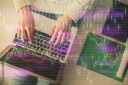 Double exposure of woman hands working on computer and forex chart hologram drawing. Top View. Financial analysis concept.