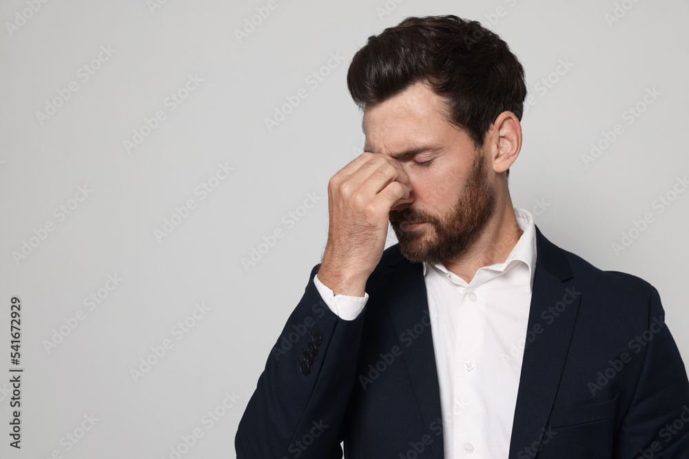 Man suffering from eyestrain on light grey background. Space for text Man suffering from eyestrain on light grey background. Space for text