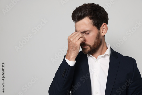 Man suffering from eyestrain on light grey background. Space for text