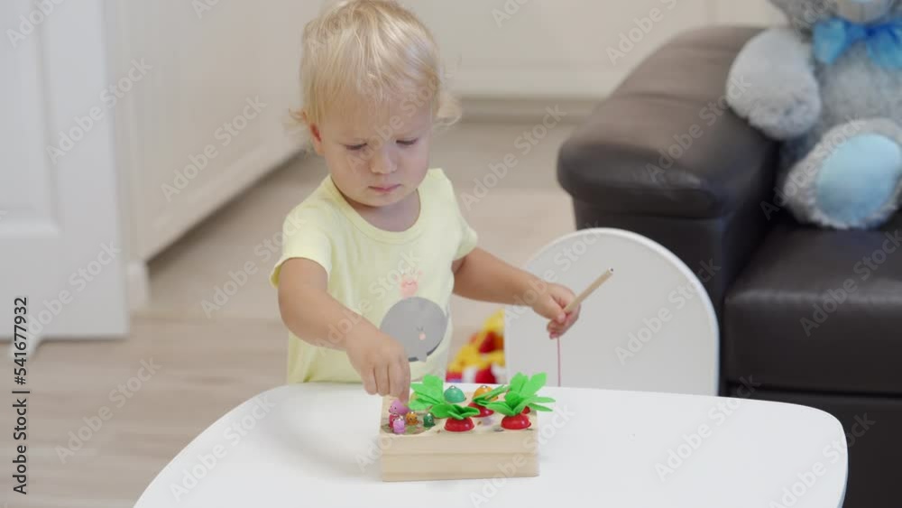 Happy toddler child playing with magnetic fishing game, wooden educational toy fish game for kids with fishing pole for fine motor skills. Happy toddler child playing with magnetic fishing game, wooden educational toy fish game for kids with fishing pole for fine motor skills.