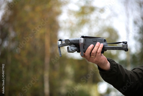 Man holding a drone with his hand before flying it through the sky