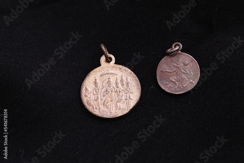 Close of 2 silver coins engraved with images of ramar kalyanam and lord hanumar, coin isolated in black background photo