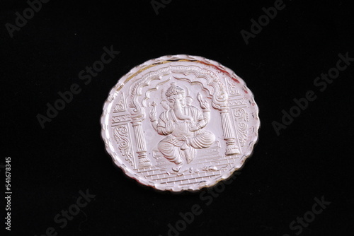 Close up of a silver coin engraved with image of Lord Ganesha. photo