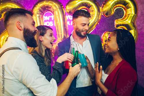 Multiracial people toasting drinks while celebrating new years eve in the club