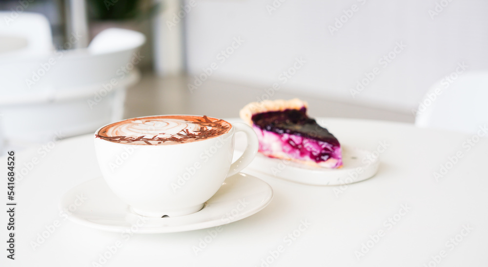 Latte art hot coffee with tulip milk latte art on top of white ceramic glass set on table in coffee shop Hot chocolate drink with white foam on top in short cup on white round table. Latte art hot coffee with tulip milk latte art on top of white ceramic glass set on table in coffee shop Hot chocolate drink with white foam on top in short cup on white round table.