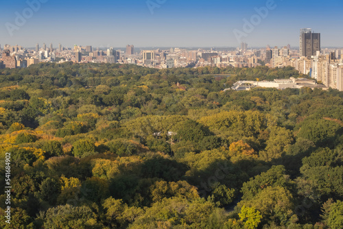 Aerial view of the Central park in Manhattan, New York with golf fields and tall skyscrapers surrounding the park. Sunset view.