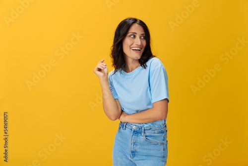 Woman signal smile with teeth emotion portrait in blue t-shirt on yellow background, hands up, surprise, lifestyle, copy space