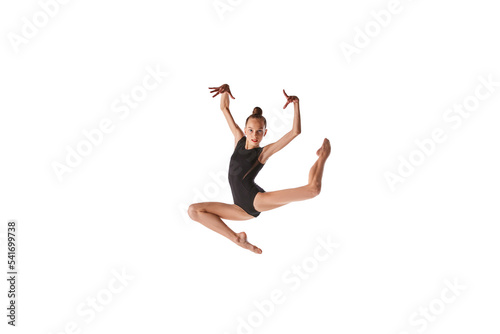 Emotions in motion. Portrait of junior gymnast in black sport swimsuit doing gymnastics excercises isolated over white background. Sport  skills  achievements
