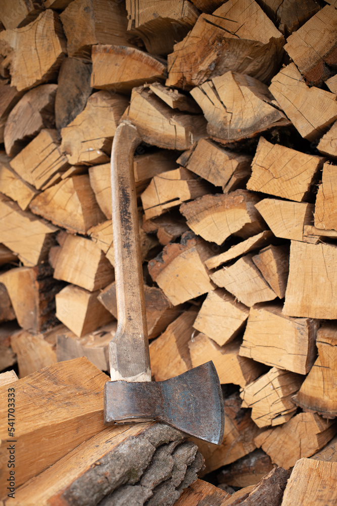 Ax on the background of stacked firewood Ax on the background of stacked firewood