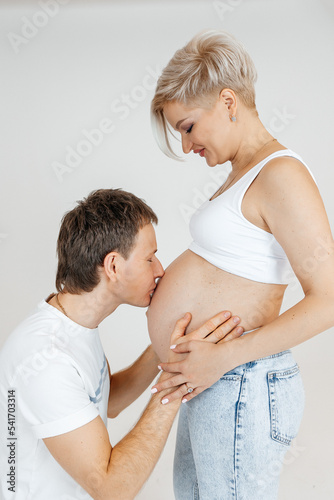 husband kissing belly of pregnant wife