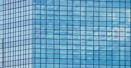 Corner of an office building made of mirrored glass windows. Building wall. Business center. Glass window. Mirror reflection. background image. Template for text. Right angle. Geometric figure.