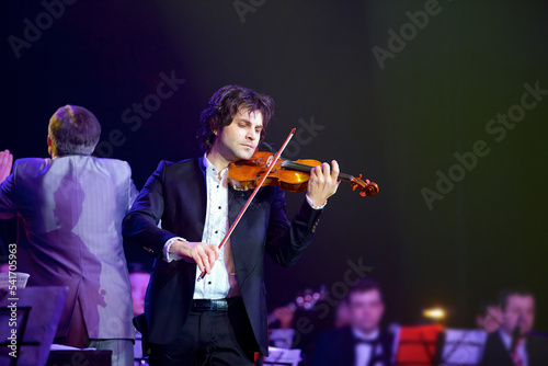 Musician violinist with a violin in his hands.