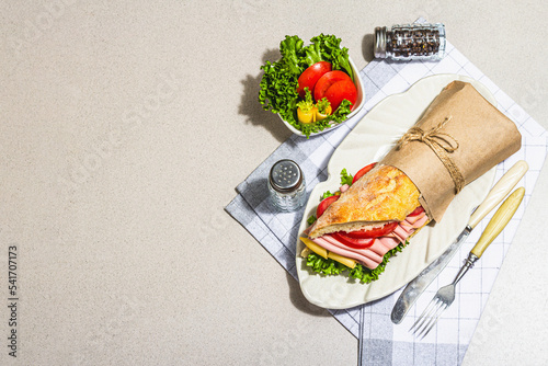 Foto Panini sandwich with ham, crispy salad and vegetables