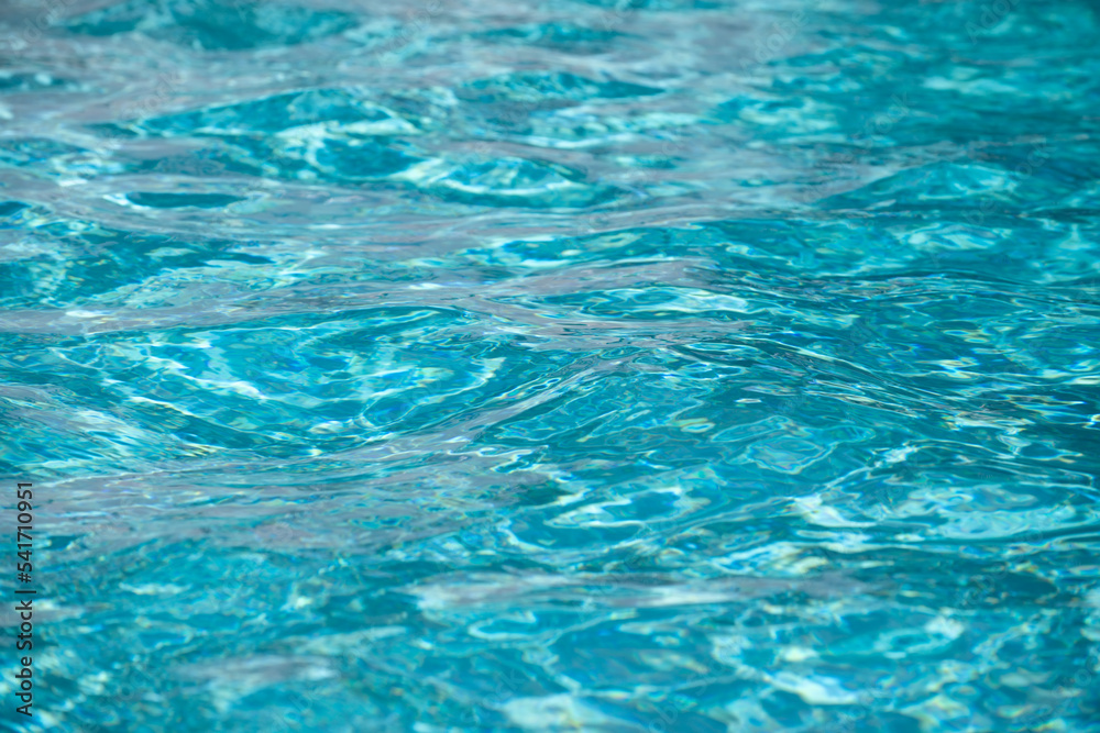 Background of blue water in swimming pool with sun reflection, ripple water wave in pool. Clear water background.