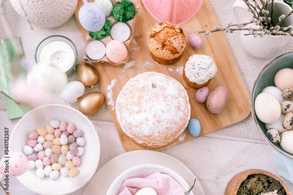 happy easter and spring holidays time. festive tablescape set decor. traditional dinner food easter eggs and baked cakes on table at home. pale pop pastel blue and pink color. top view