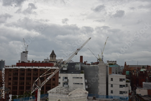 Modern buildings under construction with large cranes and machinery.  photo