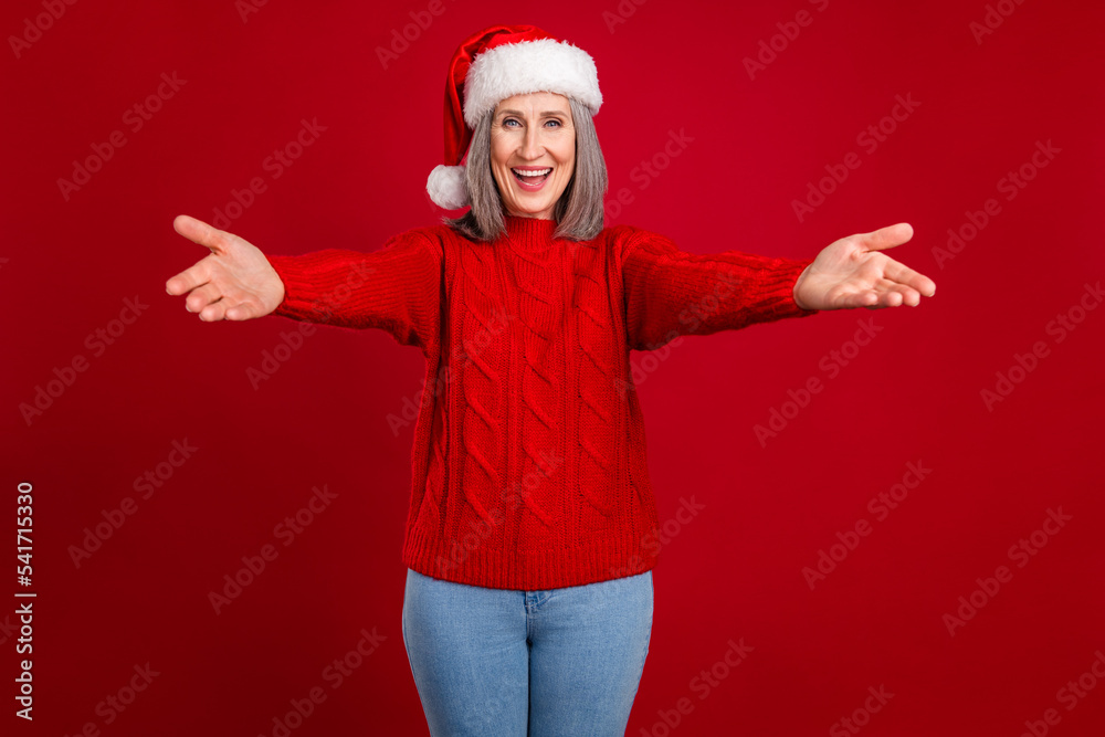Photo of positive amazed grandma stretch hands ask cuddle wear hat knitted sweater isolated red color background