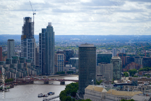 Aerial view of London with Thames River and bridge on a cloudy summer day. Photo taken August 3rd, 2022, London, United Kingdom.