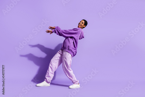Full size photo of cool young lady dance wear hoodie pants shoes isolated on purple color background
