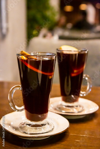 Two glasses of mulled wine on the table surrounded by New Year's lights. Festive mood