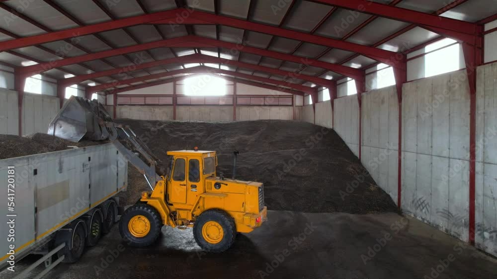 Wheel bucket loader loads a truck with sunflower seeds. High quality 4k footage. Wheel bucket loader loads a truck with sunflower seeds. High quality 4k footage.
