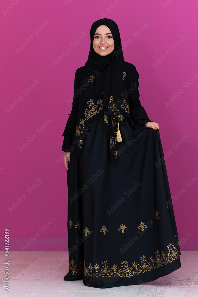 beautiful muslim woman in fashinable dress with hijab isolated on modern pink background representing concept of modern islam and ramadan kareem