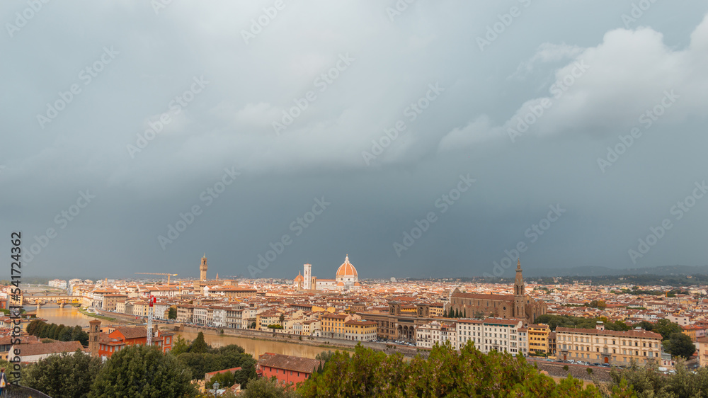 Amazing old European city with vintage houses and cathedrals with the river and the bridge on a cloudy day in Florence, Italy