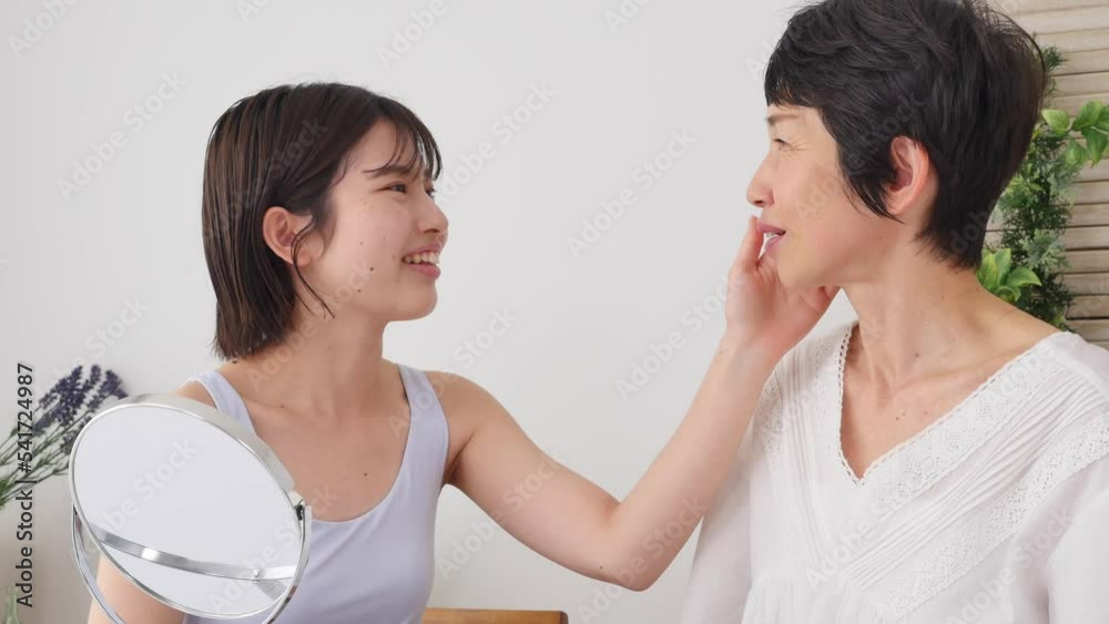 母親にスキンケアの相談する娘 母親にスキンケアの相談する娘