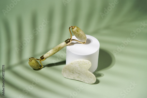 Fototapeta Naklejka Na Ścianę i Meble -  Green jade face roller and Gua Sha scraping for beauty facial massage therapy