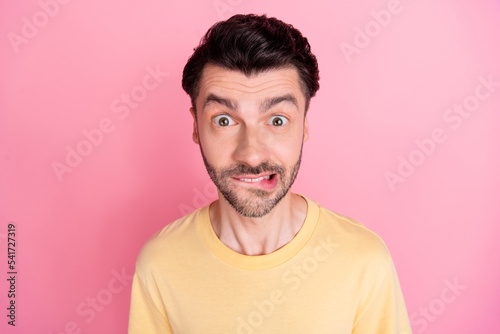 Portrait of speechless ecstatic man with stylish haircut wear yellow t-shirt impressed staring bite lips isolated on pink color background