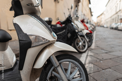 Motorcycles are parked on the street in a European town in Italy. Mopeds urban transport. Bikes photo