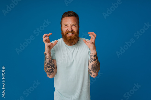 Εκτύπωση καμβά Adult bearded tattooed handsome stylish insidious man with raised hands