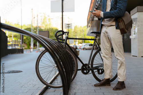 Wallpaper Mural Ginger man using cellphone while standing with bicycle on city street Torontodigital.ca