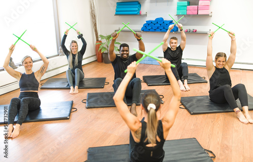 Fitness Teachers with Green Drum Stick at the gym with a training group of peole photo