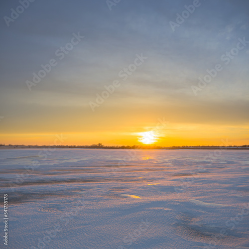 frozen snowbound lake at the sunset
