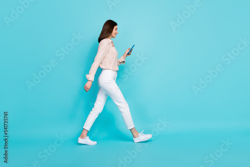 Full length photo of charming lady trendy clothes use twitter facebook texting comment blog empty space isolated on cyan color background