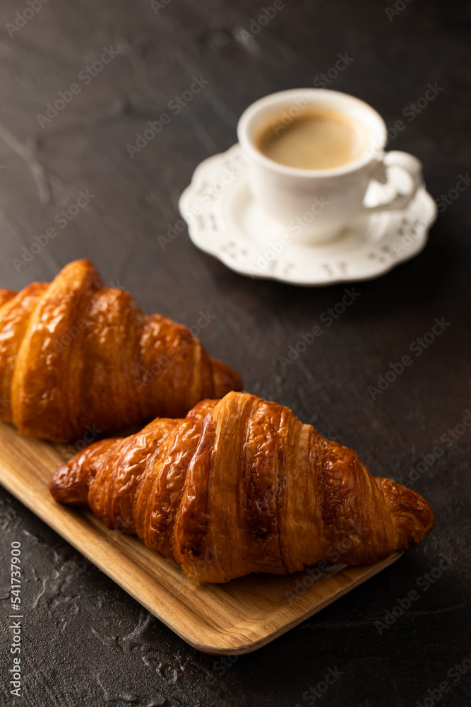 Croissants and coffee on dark background