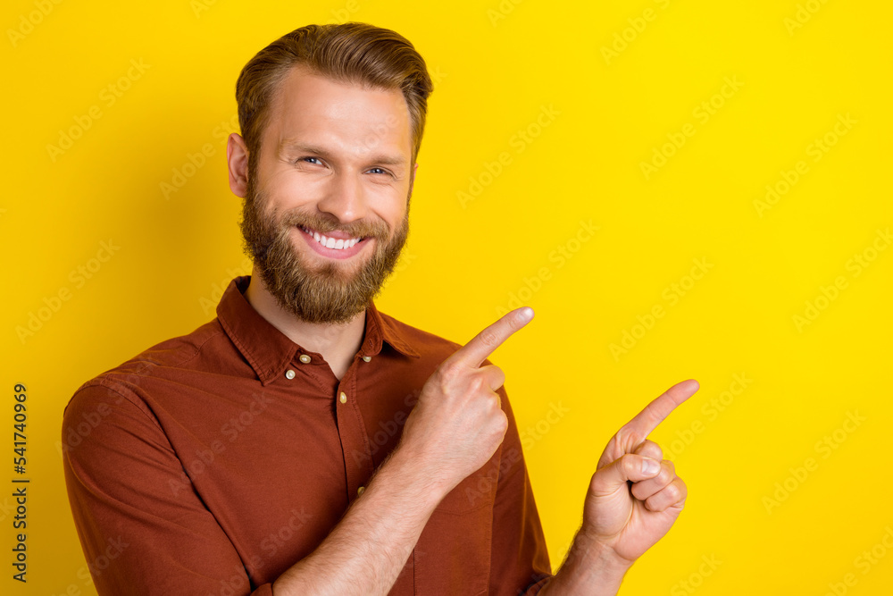 Portrait of good mood handsome man with masculine beard wear burgundy shirt directing empty space isolated on yellow color background Portrait of good mood handsome man with masculine beard wear burgundy shirt directing empty space isolated on yellow color background