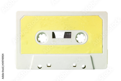 Close-up front shot: an old vintage cassette tape (obsolete music technology). Pale yellow label over a snow plastic body. 