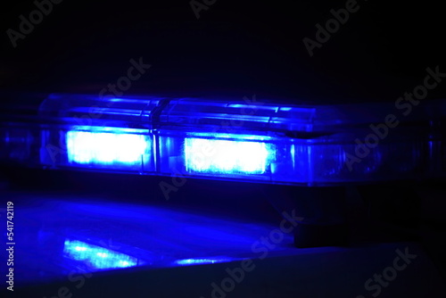 Police car with blue light on the street at night, selective focus © Art Johnson