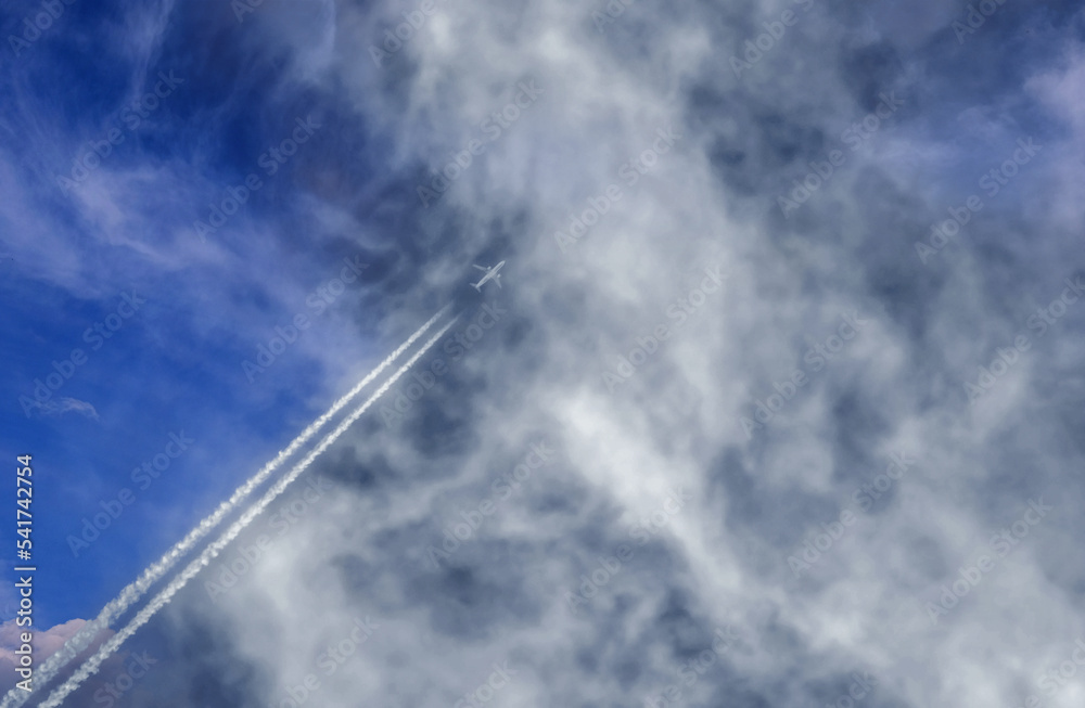 Flugzeug zieht Kondensstreifen hinter sich, steigt in den Wolkenhimmel Flugzeug zieht Kondensstreifen hinter sich, steigt in den Wolkenhimmel