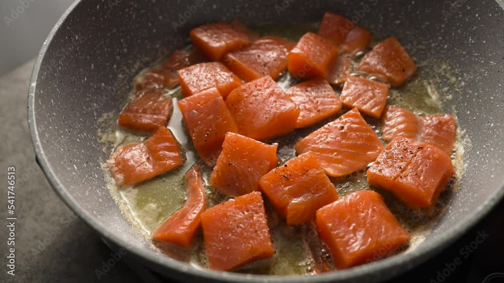 Cooking roasted pieces of salmon or trout fish in hot a pan Cooking roasted pieces of salmon or trout fish in hot a pan