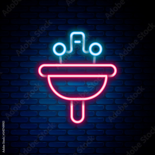 Glowing neon line Washbasin with water tap icon isolated on brick wall background. Colorful outline concept. Vector