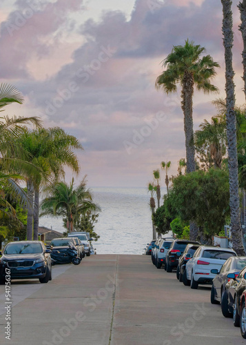 Vertical Puffy clouds at sunset Vehicles parked on the concrete road at La Jolla, California © Jason