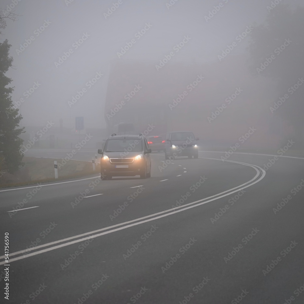 Bad weather driving - foggy hazy country road. Motorway - road traffic. Winter time. Autumn - fall. Bad weather driving - foggy hazy country road. Motorway - road traffic. Winter time. Autumn - fall.