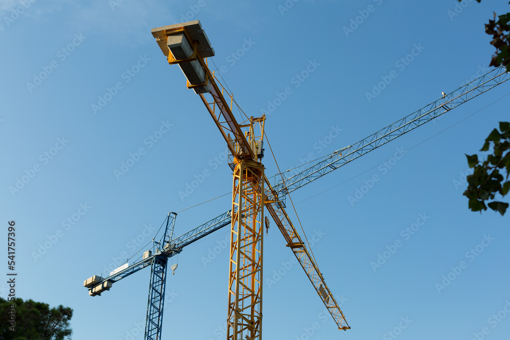 cranes at work on a construction site helping to transport building materials, including cranes at work on a construction site helping to transport building materials, including