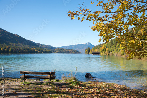 Foto bench at lake shore Walchensee, view to Herzogstand mountain, autumnal landscape