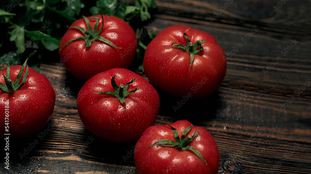 ripe juicy tomatoes on a wooden board.